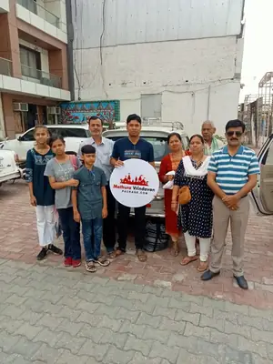 Family group photo outside hotel with Mathura Vrindavan Package board
