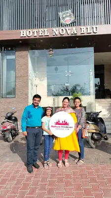 Family outside Hotel Nova Blu in Mathura with Mathura Vrindavan Package board
