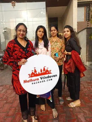 Women travellers holding the Mathura Vrindavan Package board