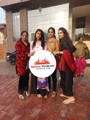 Group of women pilgrims with board outside hotel in Vrindavan