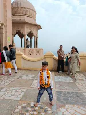Child wearing a garland on a Vrindavan temple terrace